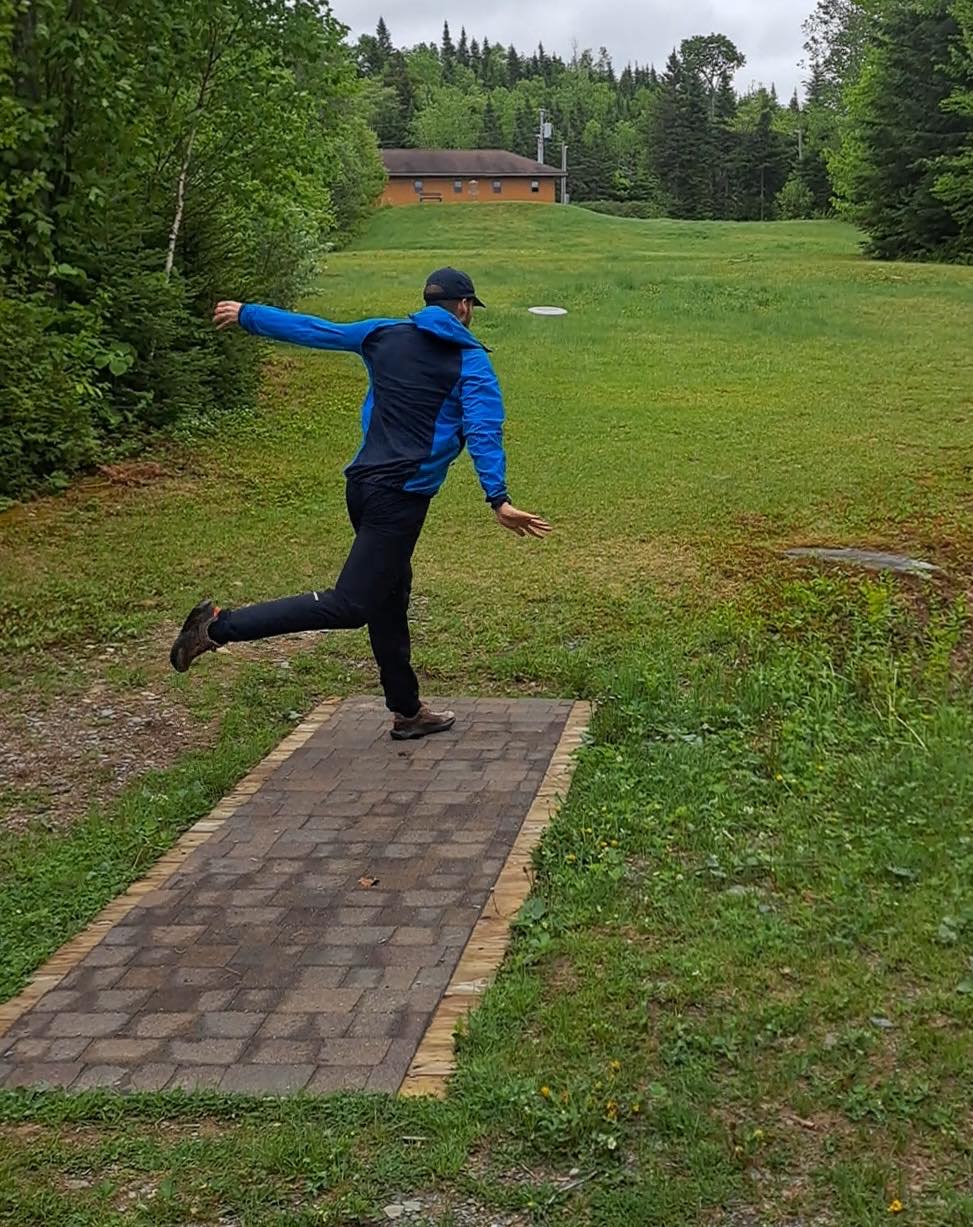 A player drives off the tee pad on the FKOC disc golf course