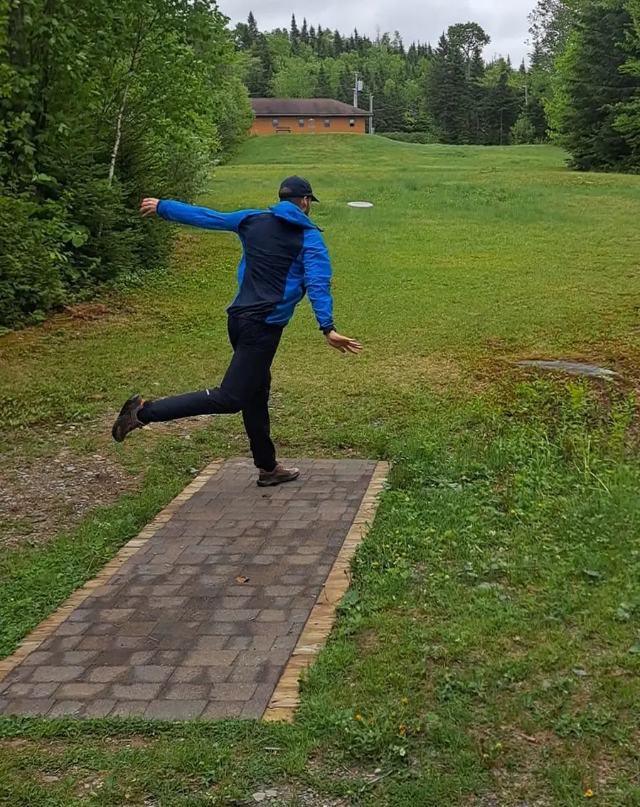 A player drives off the tee pad on the FKOC disc golf course